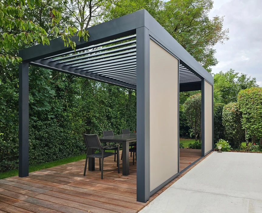 Pergola bioclimatique aluminium anthracite avec toiture à lames orientables, installée sur terrasse en bois composite