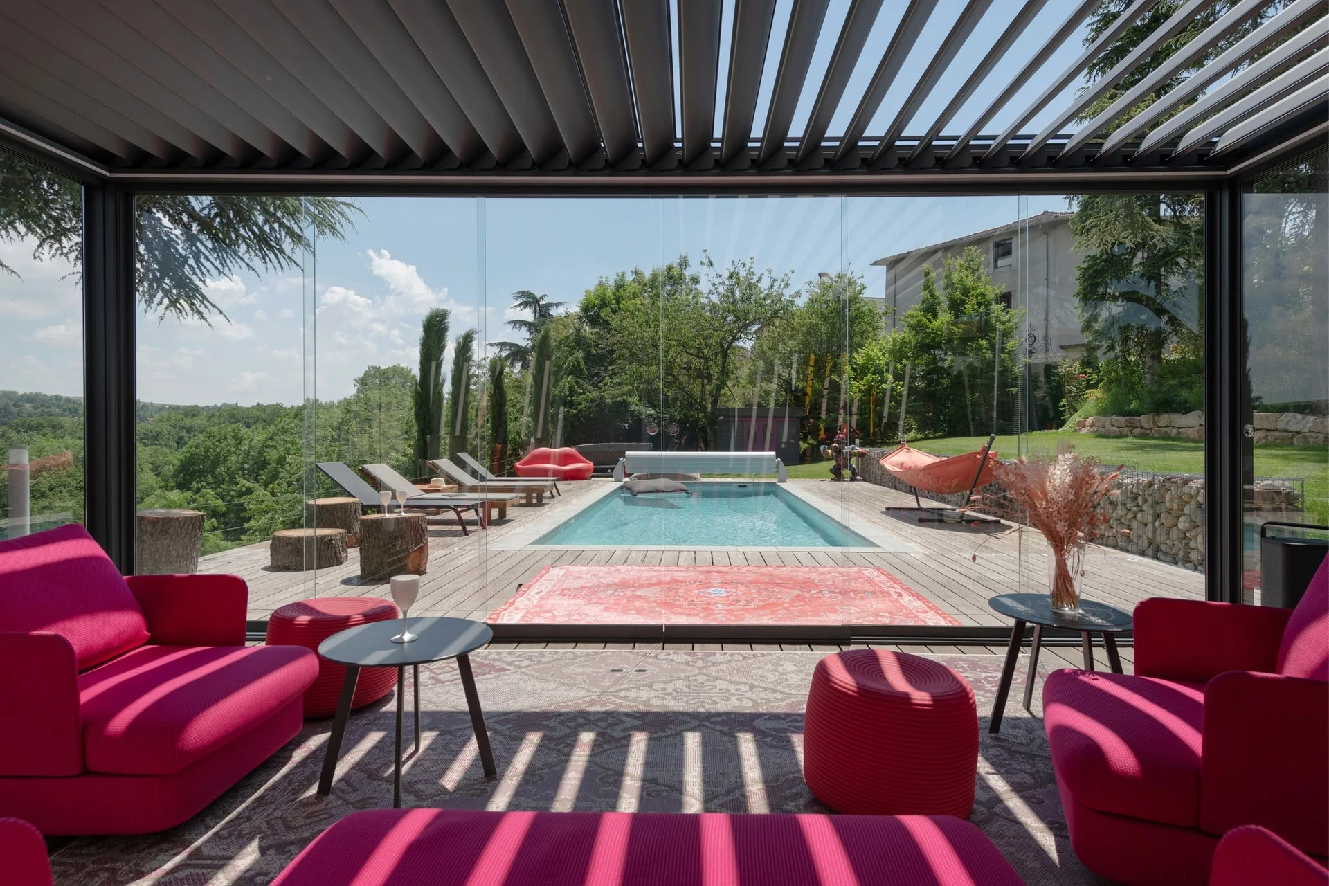 Extérieur jour, pergola moderne avec structure métallique anthracite et toiles tendues blanches créant zones d'ombrage