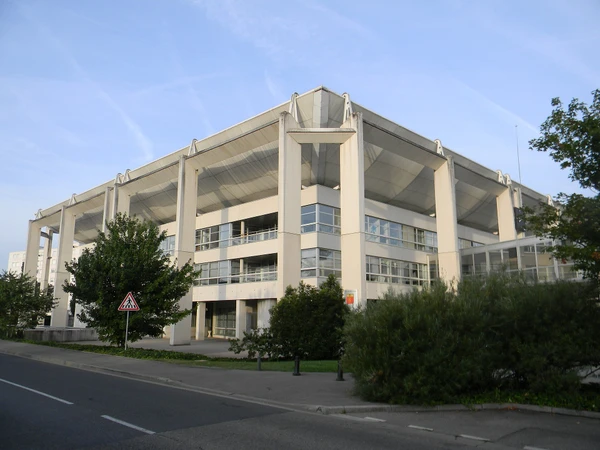 Photographie aérienne ou vue panoramique de la ville de Meyzieu montrant l'architecture urbaine caractéristique, les zones résidentielles, les rues principales et l'environnement urbain de cette commune de la métropole lyonnaise à l'est de Lyon. L'image doit être claire, bien éclairée, reconnaissable comme une localité de la périphérie lyonnaise, sans texte ni logo visible.