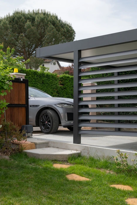 Pergola bioclimatique aluminium anthracite en extérieur, structure autoportante avec toiture à lames orientables motorisées en position fermée