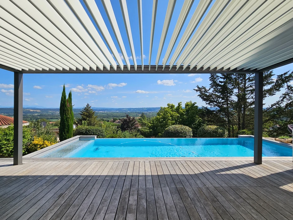 Pergola bioclimatique aluminium laqué gris, structure autoportante à toiture plate avec lames orientables