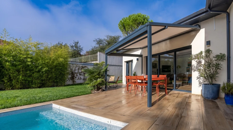 Extérieur jour, pergola moderne avec structure métallique grise et toile d'ombrage beige tendue
