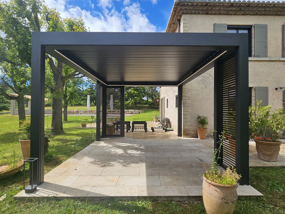 Pergola bioclimatique aluminium blanc installée en terrasse, avec lames orientables apparentes