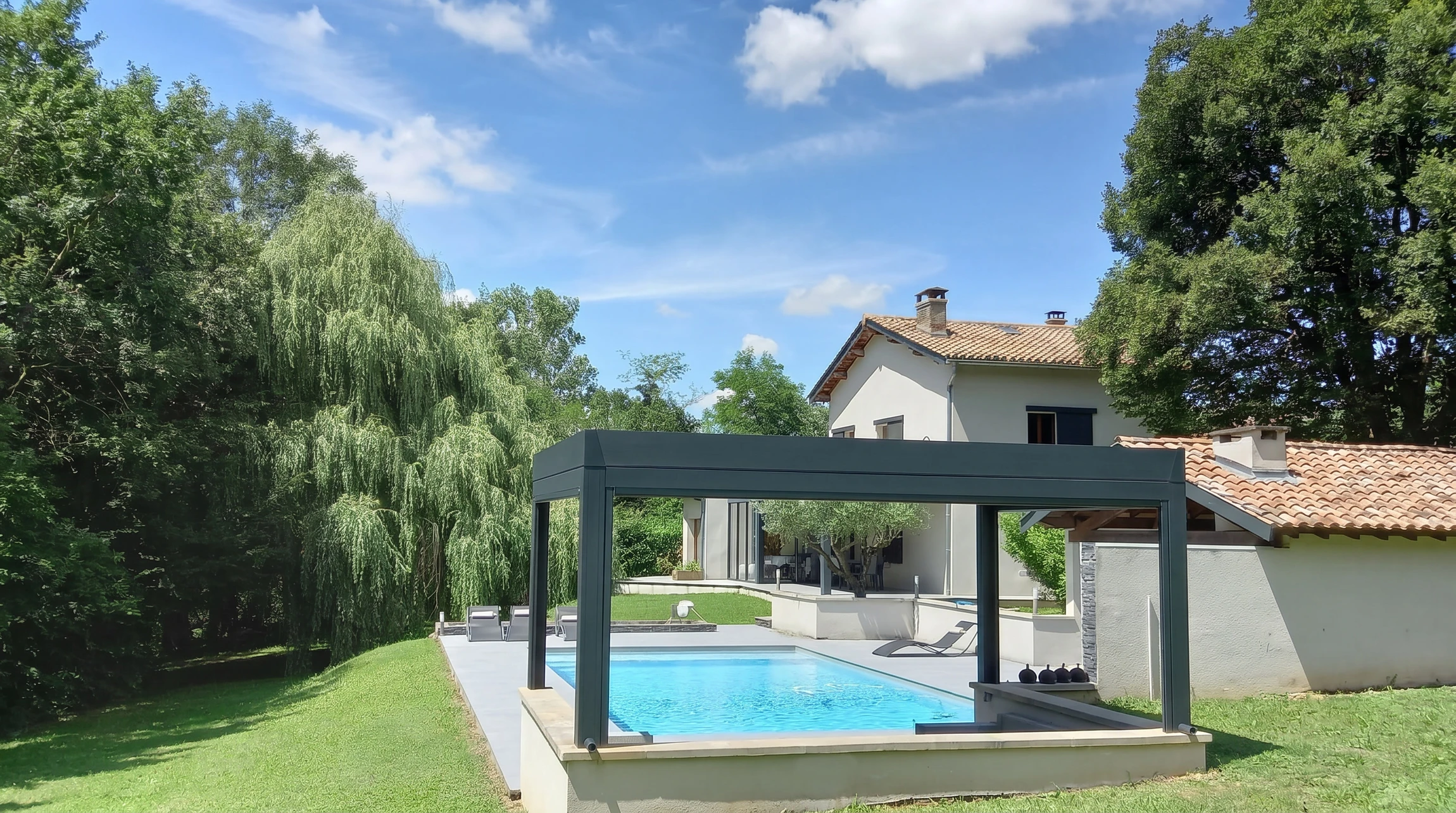 Scène extérieure montrant une pergola moderne en cours de construction ou terminée, photographiée en contre-plongée sous un ciel bleu dégagé