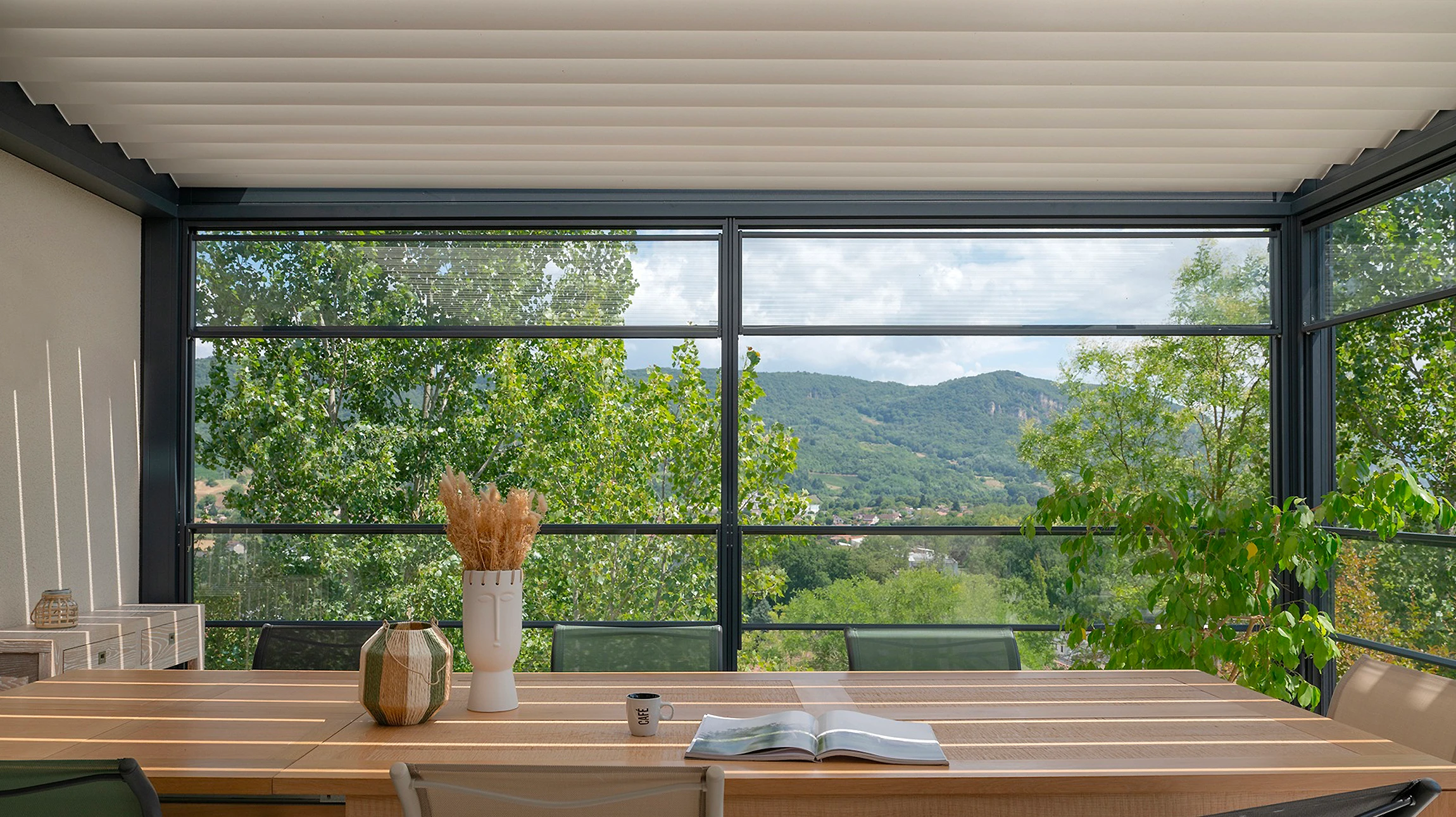 Véranda moderne à structure aluminium anthracite avec toiture plate et vitrages panoramiques