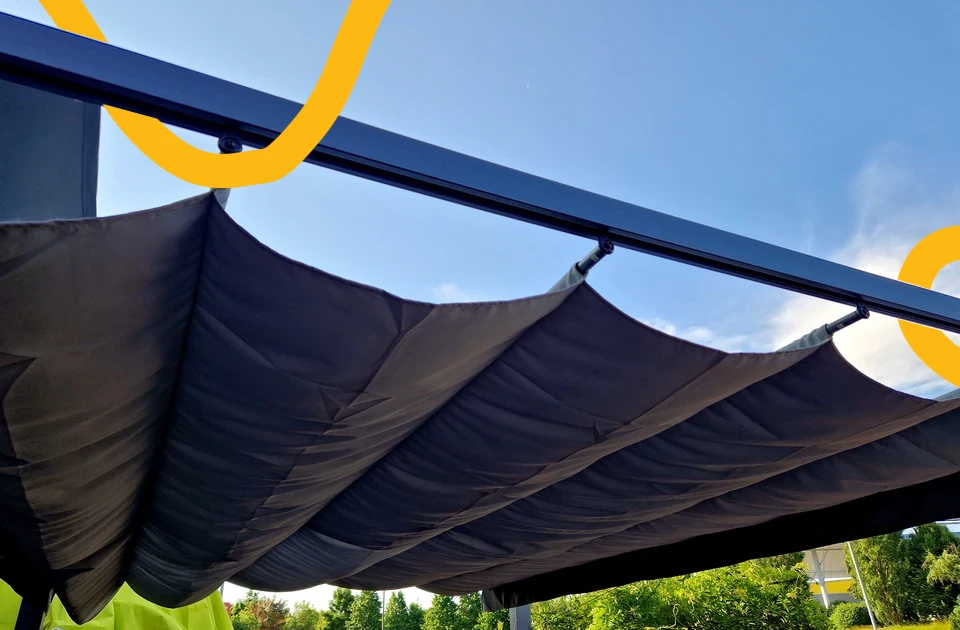 Extérieur jour, pergola moderne avec structure métallique grise et toile d'ombrage beige tendue